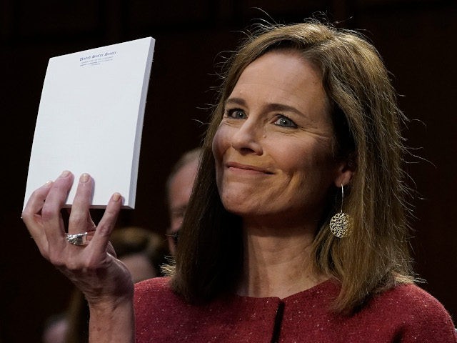 Judge Amy Coney Barrett, holds up a blank notepad after Senator John Cornyn asked her what