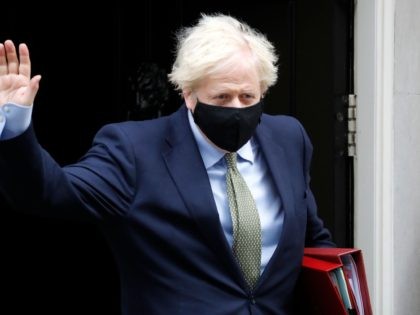 Britain's Prime Minister Boris Johnson wearing a face mask or covering due to the COVID-19 pandemic, waves as he leaves number 10 Downing Street in central London on October 14, 2020, to take part in the Prime Minister Question (PMQs) session in the House of Commons. (Photo by Tolga AKMEN …