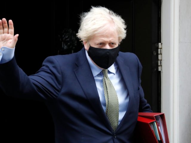 Britain's Prime Minister Boris Johnson wearing a face mask or covering due to the COV