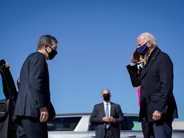 MORRISVILLE, NC - OCTOBER 18: North Carolina Governor Roy Cooper (L) greets Democratic presidential nominee Joe Biden upon arrival at Raleigh-Durham International Airport on October 18, 2020 in Morrisville, North Carolina. Biden is headed to a campaign event at Riverside High School in Durham, North Carolina. (Photo by Drew Angerer/Getty …