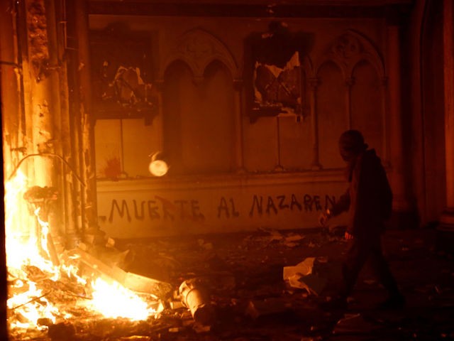 SANTIAGO, CHILE - OCTOBER 18: Masked men burn down a Carabineros church during a protest on October 18, 2020 in Santiago, Chile. A series of protests and social unrest arose after a subway fare increase. It developed in a movement demanding improvements in basic services, fair prices and benefits including pensions, public health, and education. As a result, Chile will hold a referendum next Sunday to to decide whether or not to modify the Pinochet-era constituion. (Photo by Marcelo Hernandez/Getty Images)