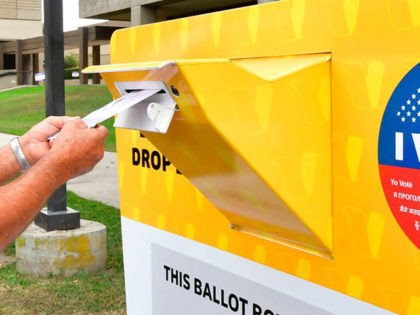A voter drops his ballot for the 2020 US elections into an official ballot drop box at the Los Angeles County Registrar in Norwalk, California on October 19, 2020. - Voter turnout is ten times higher than in 2016 in California according the Secretary of State Alex Padilla as over …