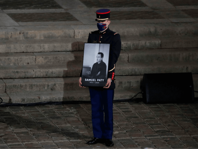 A French Republican Guard holds a portrait inside Sorbonne University's courtyard in Paris on October 21, 2020, during a national homage to French teacher Samuel Paty, who was beheaded for showing cartoons of the Prophet Mohamed in his civics class. - France pays tribute on October 21 to a history …