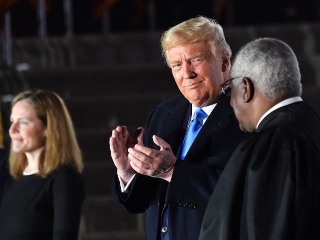 US President Donald Trump applauds next to Supreme Court Associate Justice Clarence Thomas