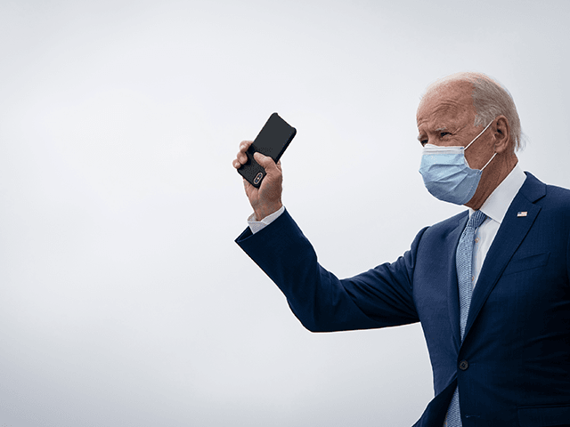 Democratic presidential nominee Joe Biden holds his phone as he arrives at Atlanta International Airport on October 27, 2020 in Atlanta, Georgia. Biden is campaigning in Georgia on Tuesday, with scheduled stops in Atlanta and Warm Springs. (Photo by Drew Angerer/Getty Images)