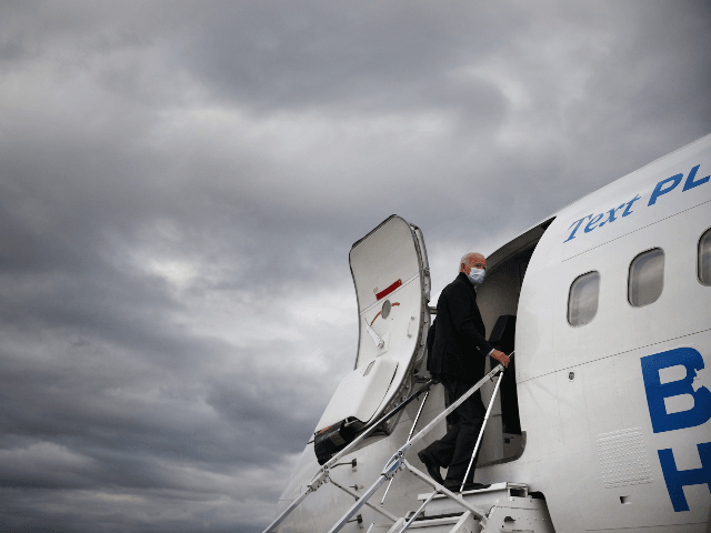 Wearing a mask to reduce the risk posed by the coronavirus, Democratic presidential nominee Joe Biden boards his plane at Gerald Ford Airport after campaigning October 02, 2020 in Grand Rapids, Michigan. Biden said he tested negative twice Friday for the coronavirus after it was reported that U.S. President Donald Trump and first lady Melania Trump tested positive for COVID-19. (Photo by Chip Somodevilla/Getty Images)