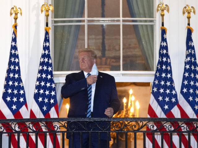 WASHINGTON, DC - OCTOBER 05: U.S. President Donald Trump removes his mask upon return to