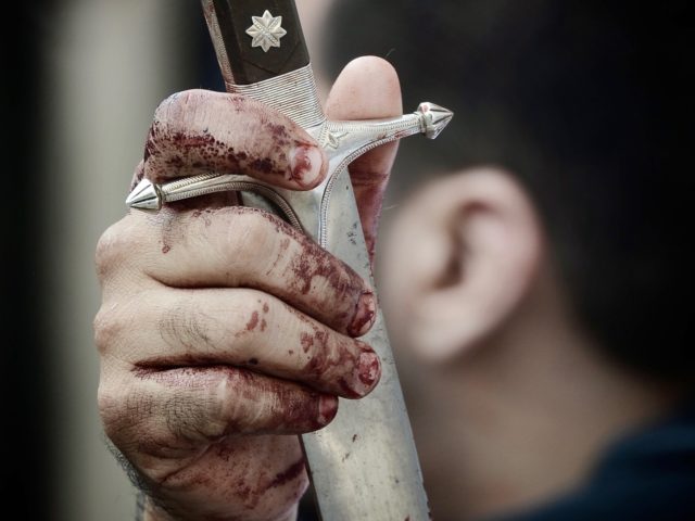 A Bahraini Shiite Muslim man holds his sword as he performs Ashura mourning rituals in Man