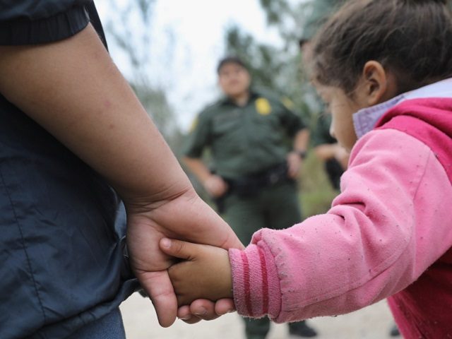 Border Patrol agent with two small children near border. (File Photo: John Moore/Getty Images)