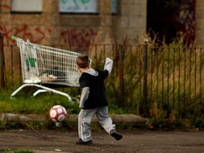 GLASGOW, UNITED KINGDOM - SEPTEMBER 30: (Editor’s note – since these images were taken the street pictured has been demolished) Two young boys play football in the street, September 30, 2008 in the Govan area of Glasgow, Scotland. A report by the Campaign to End Child Poverty suggests that millions …