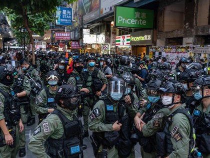 HONG KONG, CHINA - OCTOBER 01: Riot police secure an area on national day in a shopping area on October 1, 2020 in Hong Kong, China. Hong Kong police arrested over 60 for unauthorised assembly after conducting stop and search operation as 6000 officers were deployed in force to prevent …
