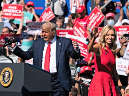 President Donald Trump gestures towards White House press secretary Kayleigh McEnany as he