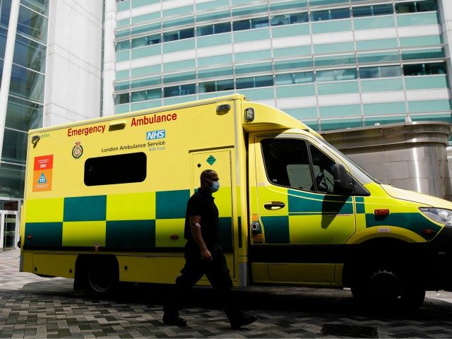 A man wearing a face mask walks past an ambulance at University College Hospital in London on July 17, 2020. - Boris Johnson said on July 17 he hoped Britain would "return to normality" by November despite being badly affected by the coronavirus and predictions of a second wave of …