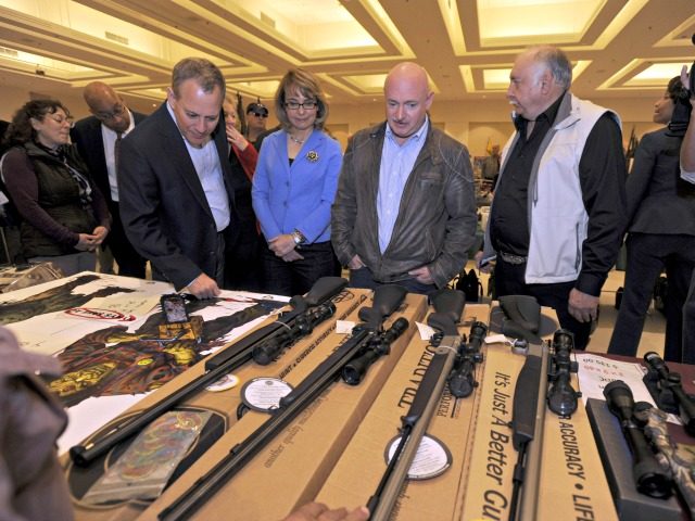 New York Attorney General Eric Schneiderman, former U.S. Rep Gabrielle Giffords, and her husband Mark Kelly, along with show organizer Dave Petronis, right, tour the New Eastcoast Arms Collectors Associates arms fair in Saratoga Springs, N.Y. on Sunday, Oct. 13, 2013. They are looking at a display of muzzle loaders. …