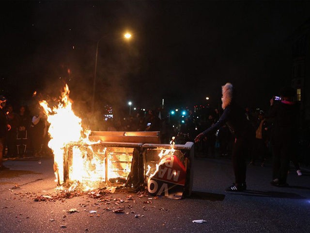 Demonstrators stand near a burning barricade in Philadelphia on October 27, 2020, during a protest over the police shooting of 27-year-old Black man Walter Wallace. - Hundreds of people demonstrated in Philadelphia late on October 27, with looting and violence breaking out in a second night of unrest after the …
