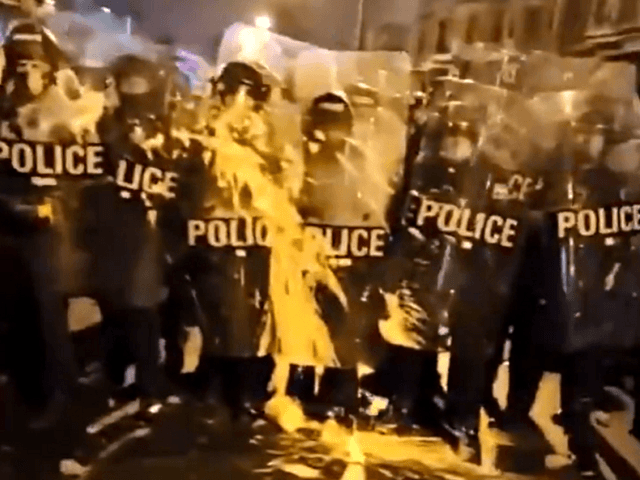 Protesters throw buckets of paint at Philadelphia police officers.