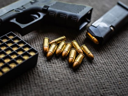 bullets and gun on black velvet desk