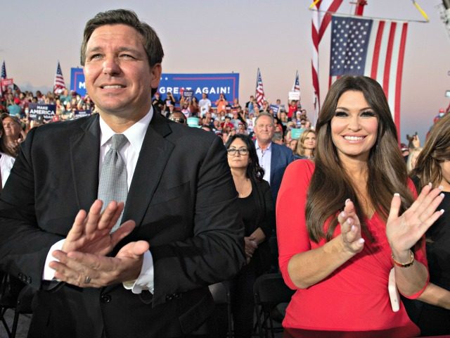 Florida Governor Ron DeSantis (L) and Kimberly Guilfoyle (R), finance chair of US President Donald Trump's campaign, applaud as Trump holds a Make America Great Again rally as he campaigns at Orlando Sanford International Airport in Sanford, Florida, October 12, 2020. (Photo by SAUL LOEB / AFP) (Photo by SAUL …