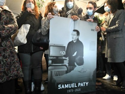 Relatives and colleagues hold a picture of Samuel Paty during the 'Marche Blanche' in Conf