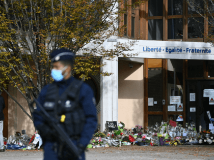 People look at flowers layed outside the Bois d'Aulne secondary school in homage to slain