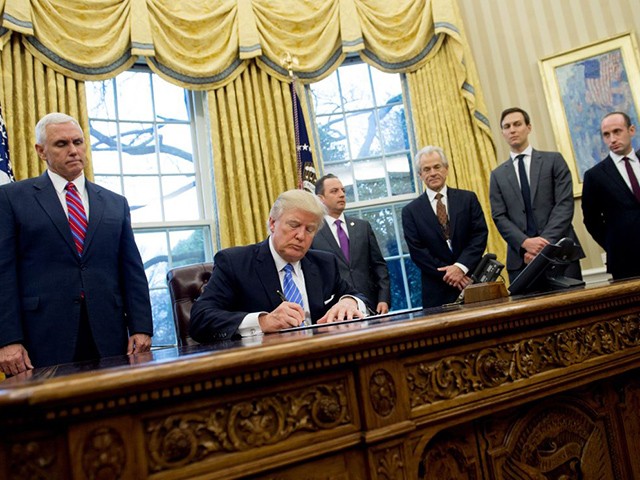 TOPSHOT - US President Donald Trump signs an executive order alongside White House Chief of Staff Reince Priebus (C), US Vice President Mike Pence (L), National Trade Council Advisor Peter Navarro (3rd R), Senior Advisor Jared Kushner (2nd R) and Senior Policy Advisor Stephen Miller in the Oval Office of the White House in Washington, DC, January 23, 2017. Trump on Monday signed three orders on withdrawing the US from the Trans-Pacific Partnership trade deal, freezing the hiring of federal workers and hitting foreign NGOs that help with abortion. / AFP PHOTO / SAUL LOEB (Photo credit should read SAUL LOEB/AFP via Getty Images)
