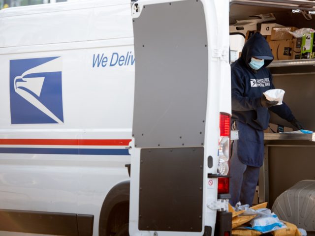 A mailman wearing a mask and gloves to protect himself and others from COVID-19, known as coronavirus, loads a postal truck with packages at a United States Postal Service (USPS) post office location in Washington, DC, April 16, 2020. - For many Americans, checking the mailbox is a daily ritual, …