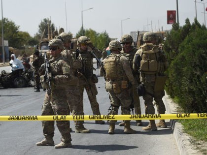 US soldiers and Afghan security personnel investigate the site of a car bomb attack that t