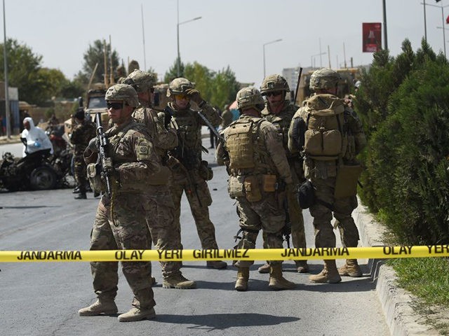 US soldiers and Afghan security personnel investigate the site of a car bomb attack that targeted a NATO coalition convoy in Kabul on September 24, 2017. A suicide bomber targeting a NATO convoy wounded three Afghan civilians in Kabul on September 24 without causing casualties among Danish troops on board, …
