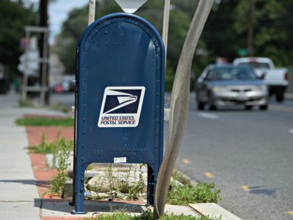 A United States Postal Service (USPS) mailbox stands in front of a post office in Washington, DC, on August 18, 2020. - The US Postal Service said on August 18 it will halt changes blamed for slowing mail delivery until after the November election, changing course in the wake of …