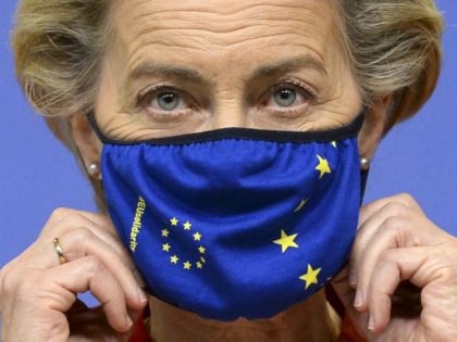 European Commission President Ursula von der Leyen adjusts her facemask ahead of deliverin