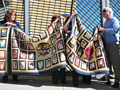 Abuse victims Jim Robertson (R) and Rita Milla (L) are joined by supporters holding quilts bearing the portraits of abused children while gathered outside the Cathedral of Our Lady of the Angels in Los Angeles, California, on February 1, 2013, one day after the release of personnel files of priests …