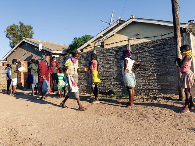 A queue of needy individuals with plates in hand forms outside Samantha Murozoki's home in Chitungwizaon May 5, 2020, where she feeds the underprivileged a free meal during the government imposed COVID-19 coronavirus lockdown period in Zimbabwe. - With the help of volunteers Samantha Murozoki serves over a 100 hot …