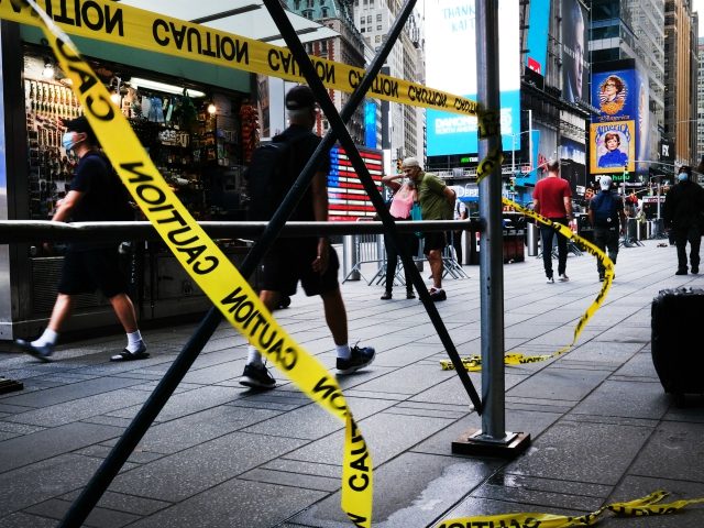 NEW YORK, NEW YORK - JUNE 30: People walk through Times Square which adjoins the Broadway