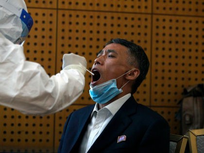 A medical staff takes a swab from a North Korean official who was invited to the commemorating conference on the 70th anniversary of the Chinese army entering North Korea to resist the U.S. army, for the coronavirus test, at a hotel in Beijing, Thursday, Oct. 22, 2020. The number of …