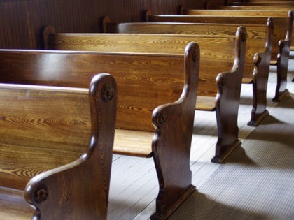 Carved Wooden pews in church in sunshine