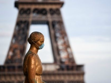 A picture taken on May 2, 2020 shows a bronze statue wearing a face mask emmulating the actions of many citizens to protecting themselves against the novel coronavirus, COVID-19 at the Parvis des Droits de l'Homme, with the Eiffel Tower in background in Paris, on the 47th day of a …