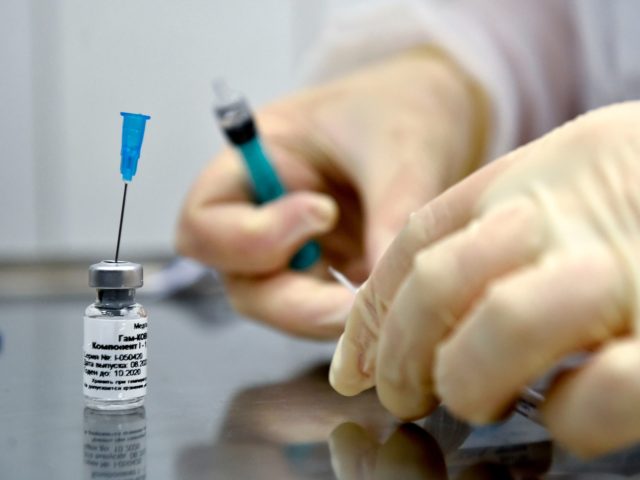 A nurse prepares to inoculate volunteer Ilya Dubrovin, 36, with Russia's new coronavirus v