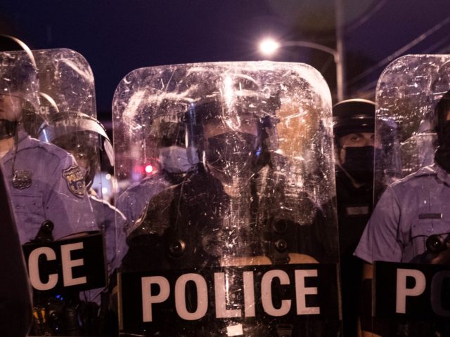 Police in riot gear face protesters marching through West Philadelphia on October 27, 2020