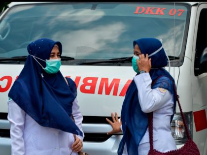 Indonesian medics wearing face masks stand in front of an ambulance in Banda Aceh on March 2, 2020. - Indonesia on March 2 reported its first confirmed case of coronavirus, after health officials in the world's fourth-most populous country hit back at questions over its apparent lack of infected patients. …