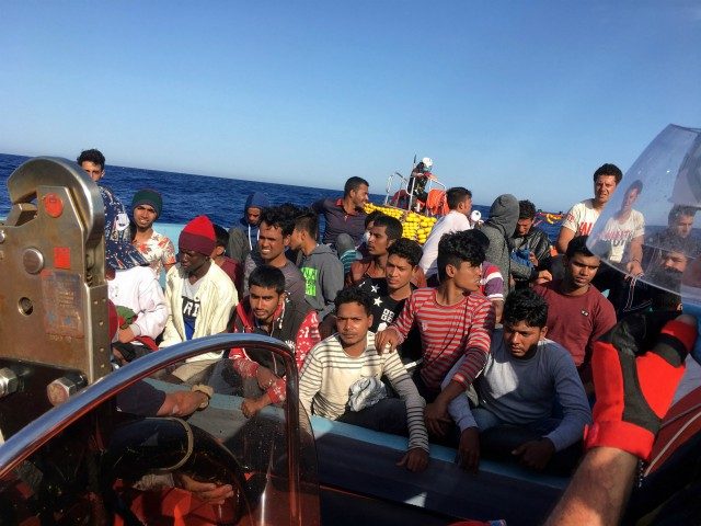 Migrants react as they are rescued by activists of French NGO SOS Mediterranee boat Ocean