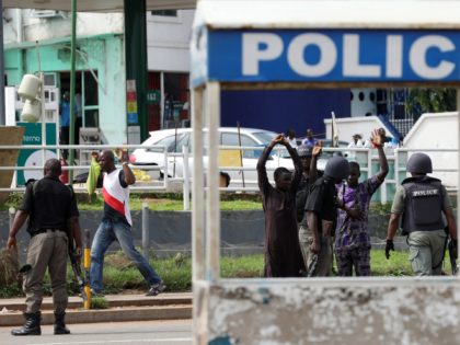 Riot policemen frisk passers-by during a violent protest by Shiite Muslims demanding the release of their detained leader Ibrahim Zakzaky in Abuja on July 23, 2019 in Abuja. - At least eight people were killed in clashes between Shiite Muslim protesters and Nigerian police in Abuja on July 22, with …