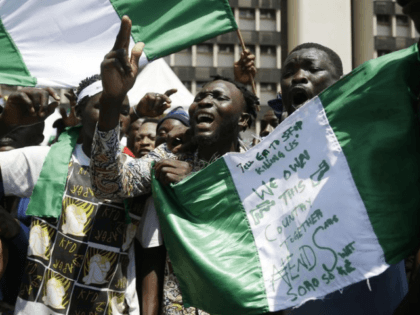People hold banners as they demonstrate on the street to protest against police brutality, in Lagos, Nigeria, Tuesday Oct. 20, 2020. After 13 days of protests against police brutality, authorities have imposed a 24-hour curfew in Lagos, Nigeria's largest city as moves are made to stop growing violence. (AP Photo/Sunday …