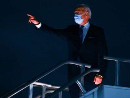 Democratic presidential nominee and former Vice President Joe Biden, wearing a facemask, acknowledges authority escorts lined nearby before taking off from Miami International Airport in Miami, Florida to head back to his hometown of Wilmington, Delaware after having participated in a Town Hall meeting on October 5, 2020. (Photo by …