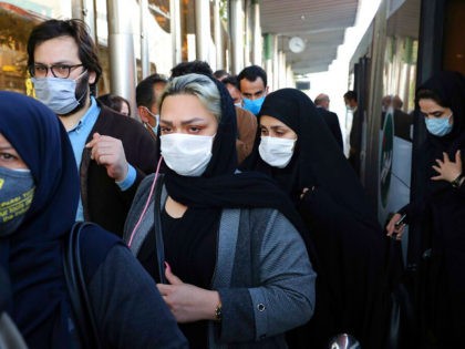 FILE - In this Sunday, Oct. 11, 2020 file photo, people wear protective face masks to help