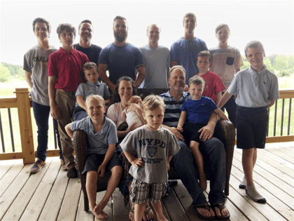 In a photo from May 30, 2018, the Schwandt family poses for a photo at their farm in Lakeview, Mich. Standing from left are Tommy, Calvin, Drew, Tyler, Zach, Brandon, Gabe, Vinny and Wesley. Seated, starting at upper left are Charlie, Luke, mother Kateri holding Finley, father Jay with Tucker …