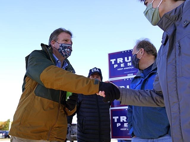 N.H. Gov. Chris Sununu shakes hands with voters at a polling station at Windham, N.H. High School, Tuesday, Nov. 3, 2020, in Windham. Sununu, a Republican, faces Democrat Dan Feltes in the gubernatorial election. (AP Photo/Charles Krupa)