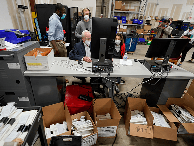 Democratic and Republican representatives review absentee ballots at the Fulton County Election preparation Center Wednesday, Nov. 4, 2020 in Atlanta. (AP Photo/John Bazemore)
