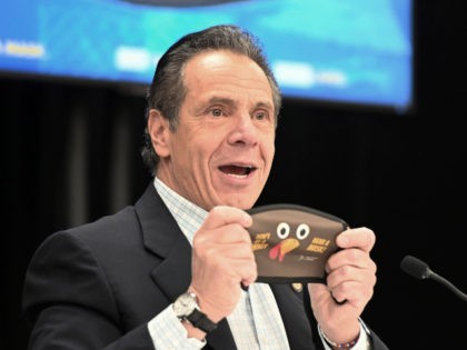 In this provided by the State of New York, New York Gov. Andrew Cuomo holds up a new Thanksgiving-themed face mask during his daily coronavirus briefing at the Wyandanch-Wheatley Heights Ambulance Corp. Headquarters in Wyandanch, N.Y. After disclosing that he will no longer be celebrating Thanksgiving with his 89-year-old mother …