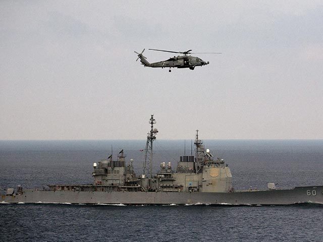 A U.S. Navy helicopter approaches to land on the deck of aircraft carrier USS Theodore Roosevelt (CVN 71), a missile cruiser and a nuclear-powered submarine, as the USS Normady sails in the Bay of Bengal during Exercise Malabar 2015, some 152 miles off eastern coast of Chennai, India, Saturday, Oct. …