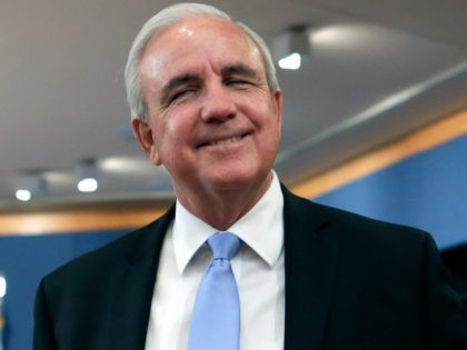 Miami-Dade Mayor Carlos Gimenez smiles at his arrival at an immigration hearing at the County building, Friday, Feb. 17, 2017, in downtown Miami. County commissioners in immigrant-rich Miami-Dade voted to uphold their Cuban-born mayor's order to cooperate with federal immigration officials. (AP Photo/Alan Diaz)